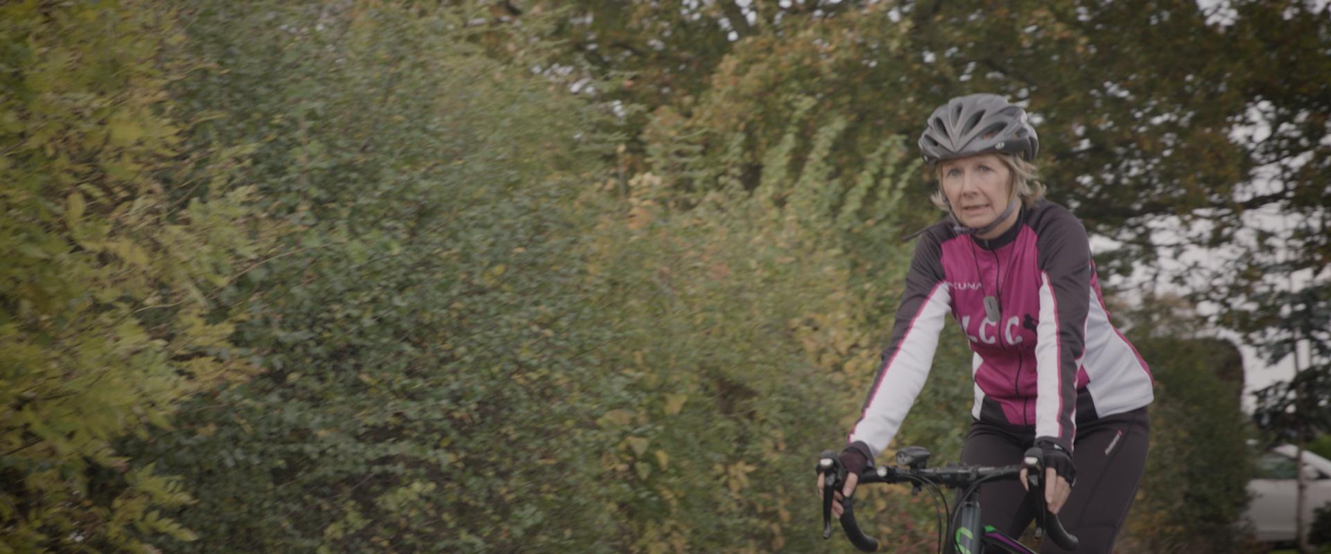 woman with hearing loss cycling down country lane